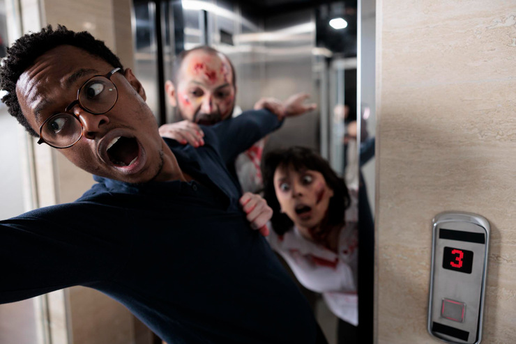 frightened adult running from cruel walkers escaping office elevator brain eating walking dead monsters attacking man terror massacre being scared afraid after bloody zombies attack
